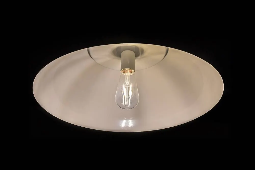 White pendant light with a glowing filament bulb on a black background