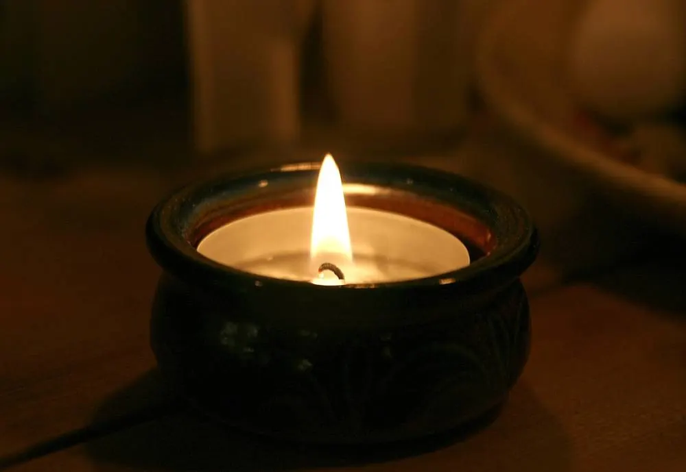 Candle flame in a dark holder