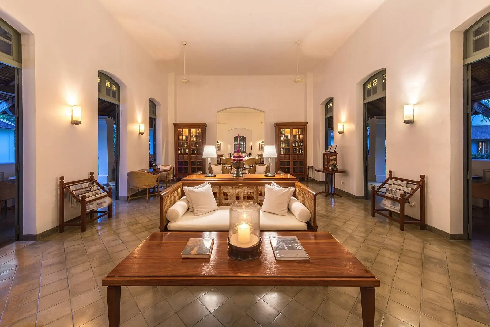 Living room at dusk, pale sofas, wooden coffee table and a candle