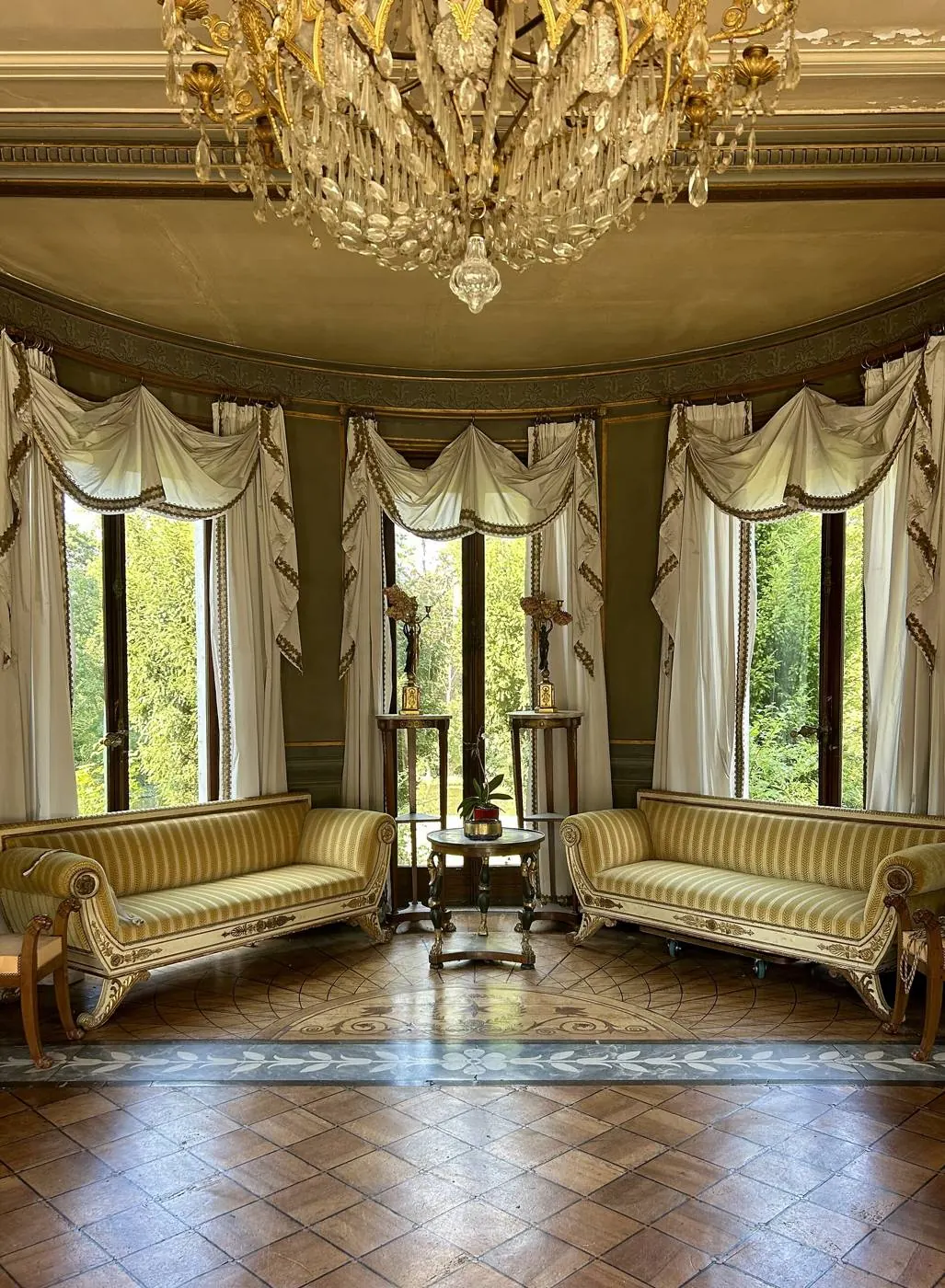 Bright period living room, tall windows, herringbone parquet and two striped sofas